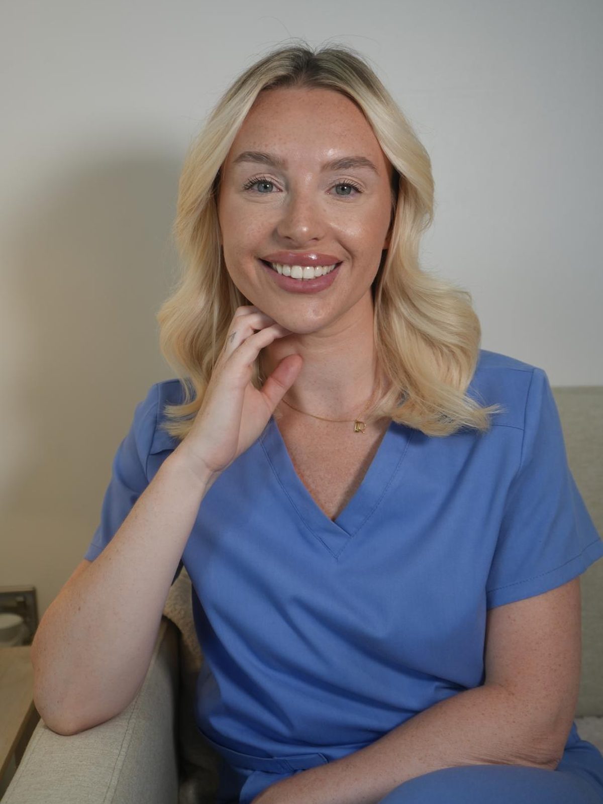 Becci, NMC registered aesthetic nurse and founder of The Face Lab, in blue scrubs